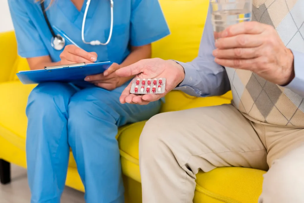 Elderly man clutching his prescription pills, focused expression.