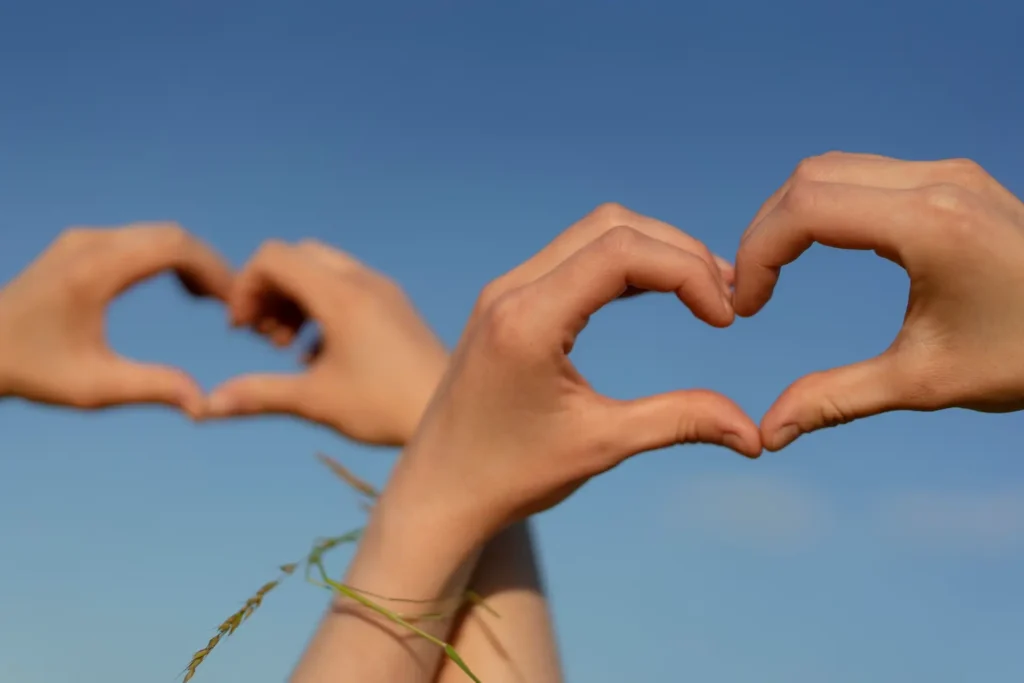 Hand gestures symbolizing friendship in a low-angle shot.