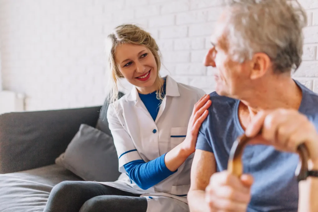 Man happily interacting with a smiling nurse at a nursing home