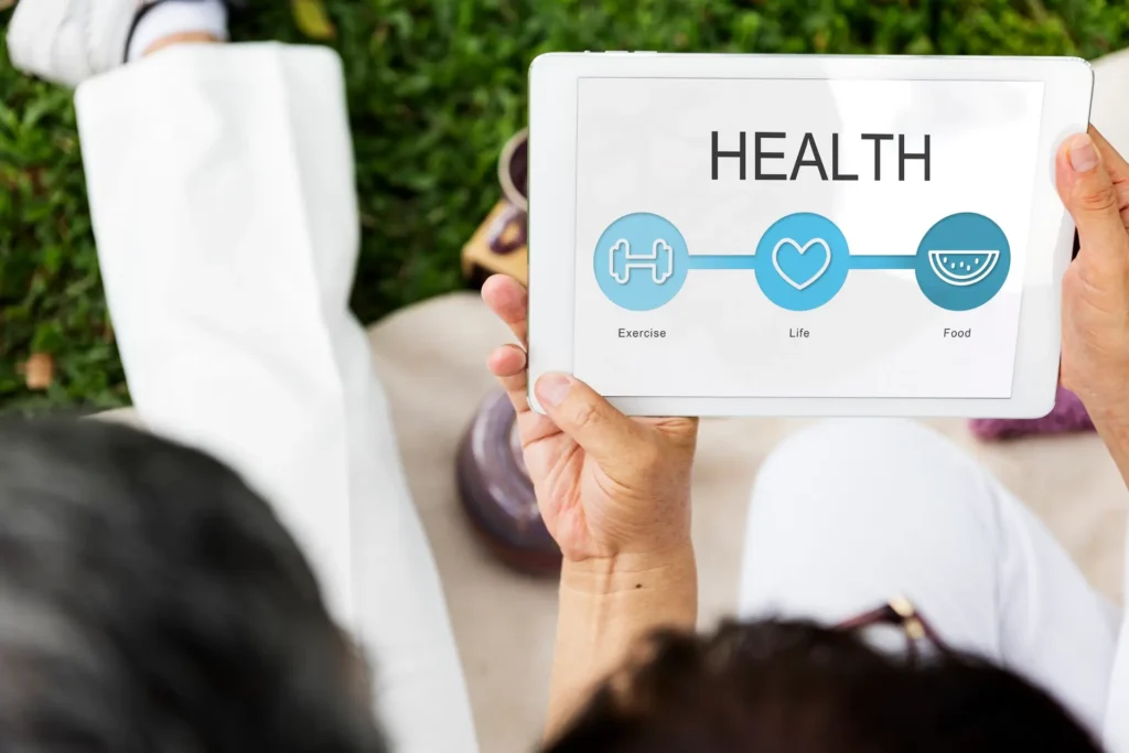 Individual monitoring health metrics on a tablet screen.